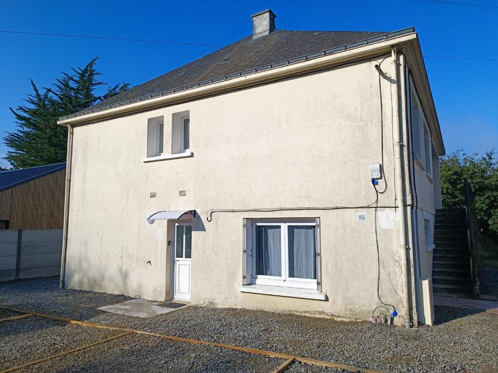 un grand bâtiment blanc avec une grande porte dans l'établissement Les Logis du Haut Bodio, à Pontchâteau