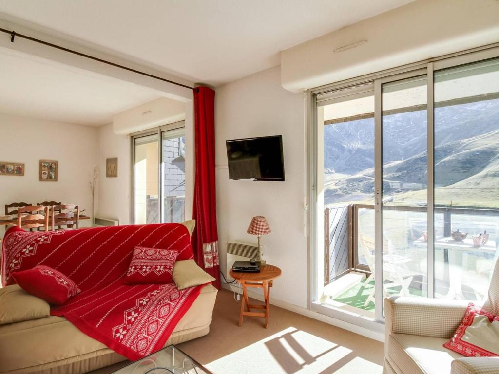 un salon avec un canapé et une grande fenêtre dans l'établissement Appartement 6 pers, balcon, pistes, parking couvert, centre station - FR-1-404-203, à La Mongie