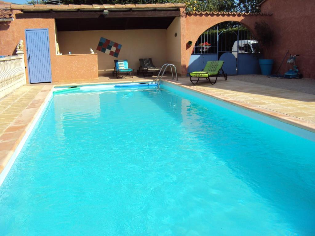 a large blue swimming pool in front of a building at B&B La Douloire in Pernes-les-Fontaines