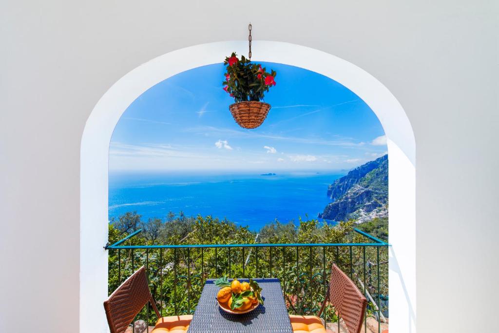 een balkon met een tafel en uitzicht op de oceaan bij L'Uliveto in Positano