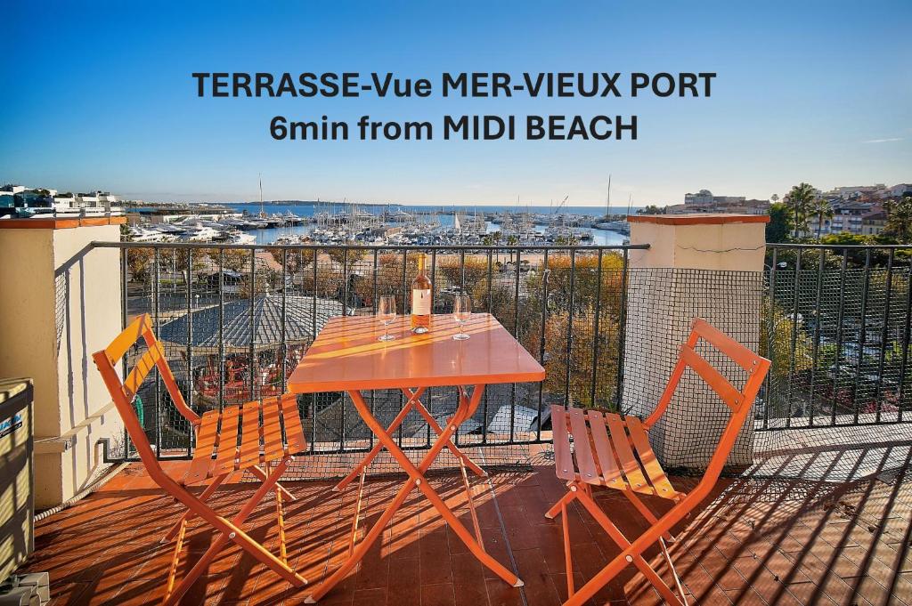 une table et des chaises en bois sur une terrasse avec vue dans l'établissement EXCEPTIONNEL 3 PIECES AVEC TERRASSE VUE SUR VIEUX PORT CENTRE VILLE l! A2B195, à Cannes