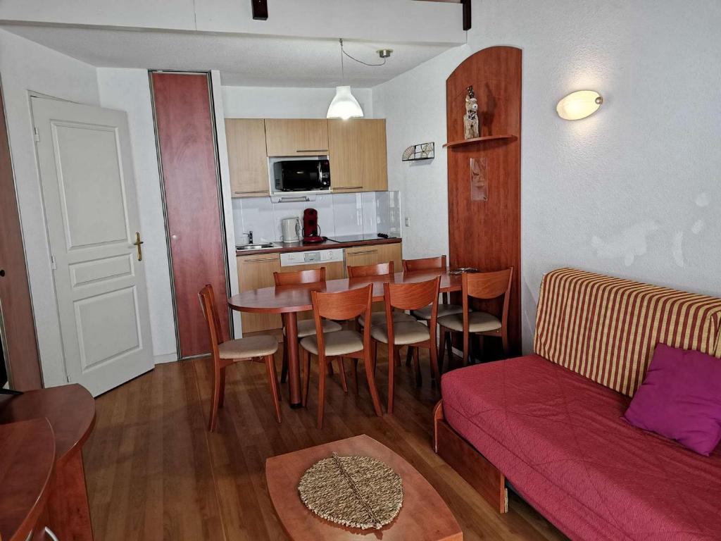 un salon avec une table et un canapé dans l'établissement Duplex avec Piscine, Salle de Fitness, Parking et Animaux Acceptés - FR-1-404-321, à Bagnères-de-Bigorre