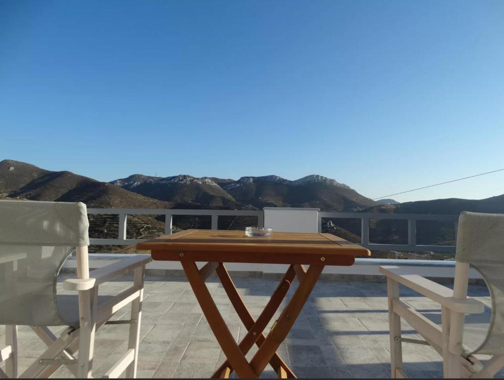 a wooden table and two chairs on a patio at Skopelitis Village in Katapola