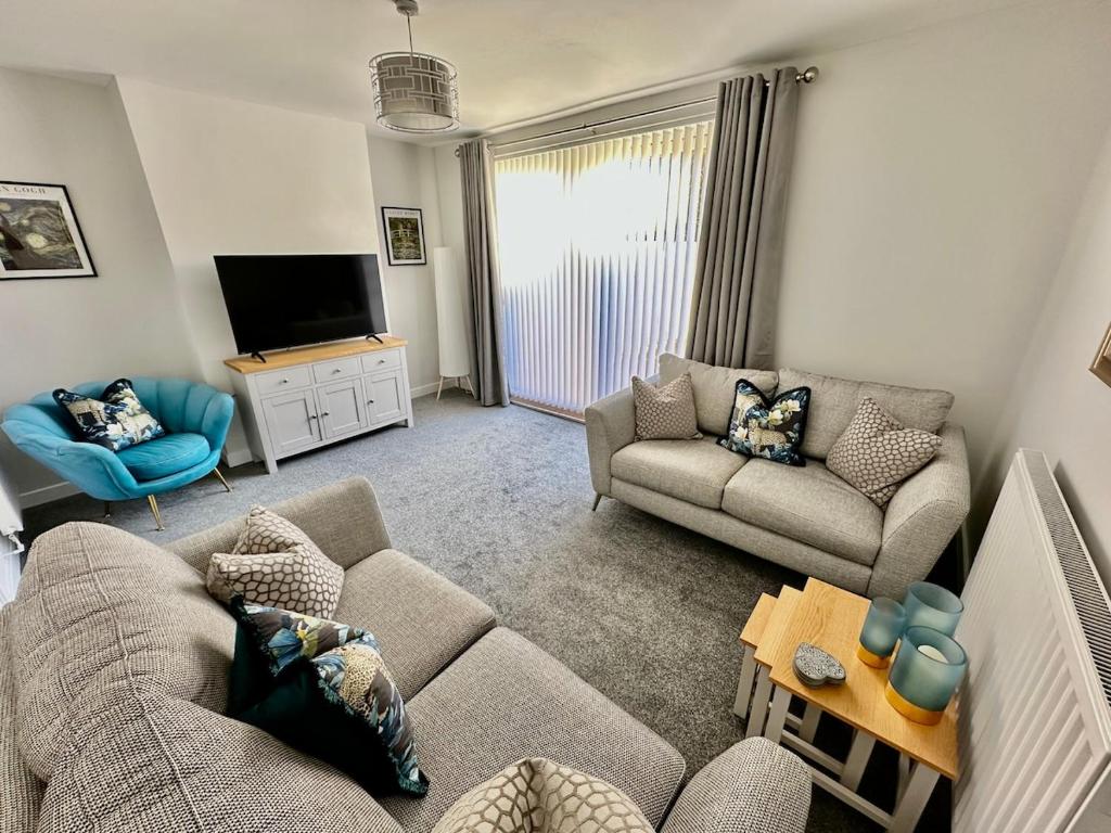 Una sala de estar con dos sofás y un televisor. en Beautifully Spacious 3 Bed Home, en Kenton