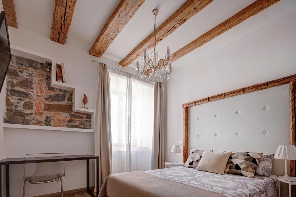 a bedroom with a bed and a chandelier at la Maison de Trieste Suite garage in centro 5 persone vicino Piazza Unità in Trieste