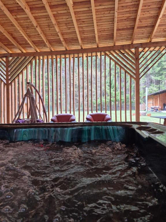 a swimming pool in a building with a playground at Doftana Nature Events in Trăisteni