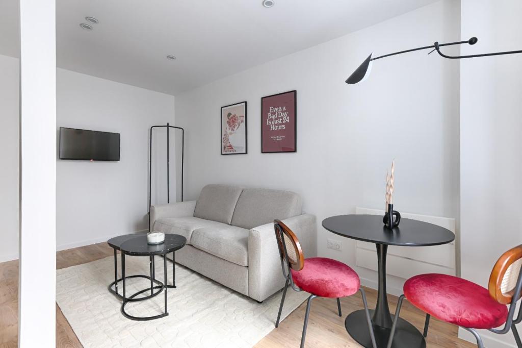 un salon avec un canapé, une table et des chaises dans l'établissement CIA - Lovely Studio East Paris, à Paris