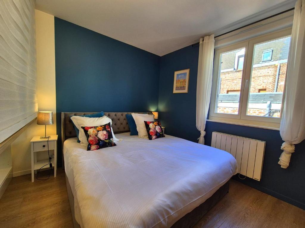 une chambre avec un grand lit aux murs bleus dans l'établissement Les Loges du Beffroi - L'azur, à Arras