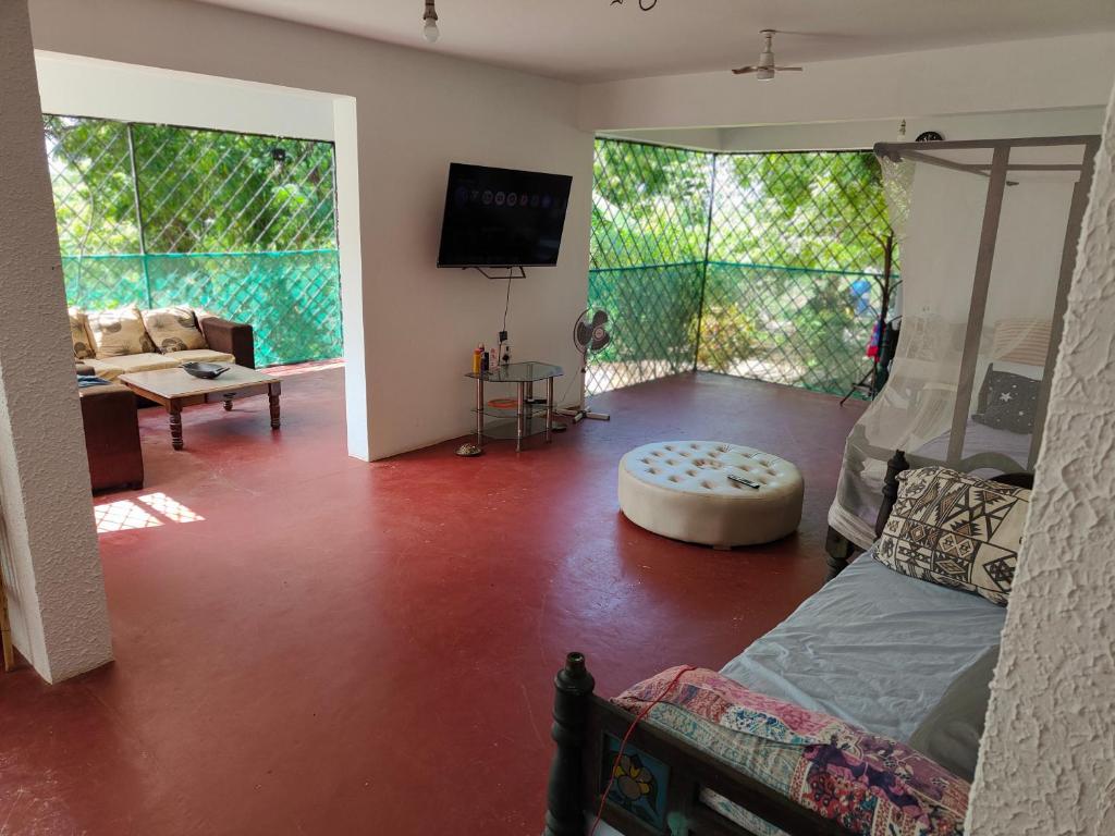 Baba Yaga Nest Beach Farm House في Gatunga: غرفة معيشة بها سرير وأريكة