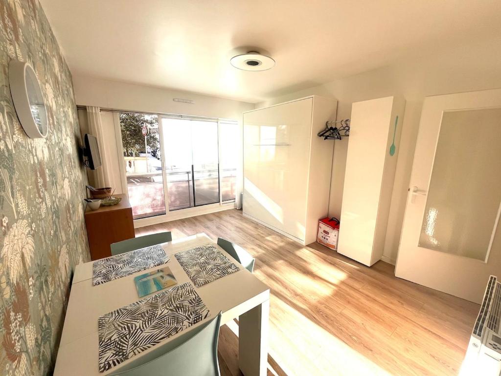 une salle à manger avec une table et des chaises dans une pièce dans l'établissement Les Pieds dans leau avec parking, à Les Sables-dʼOlonne