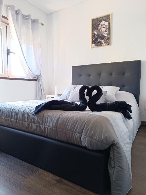 a bedroom with a bed with two swans on it at Reis Apartment in Porto