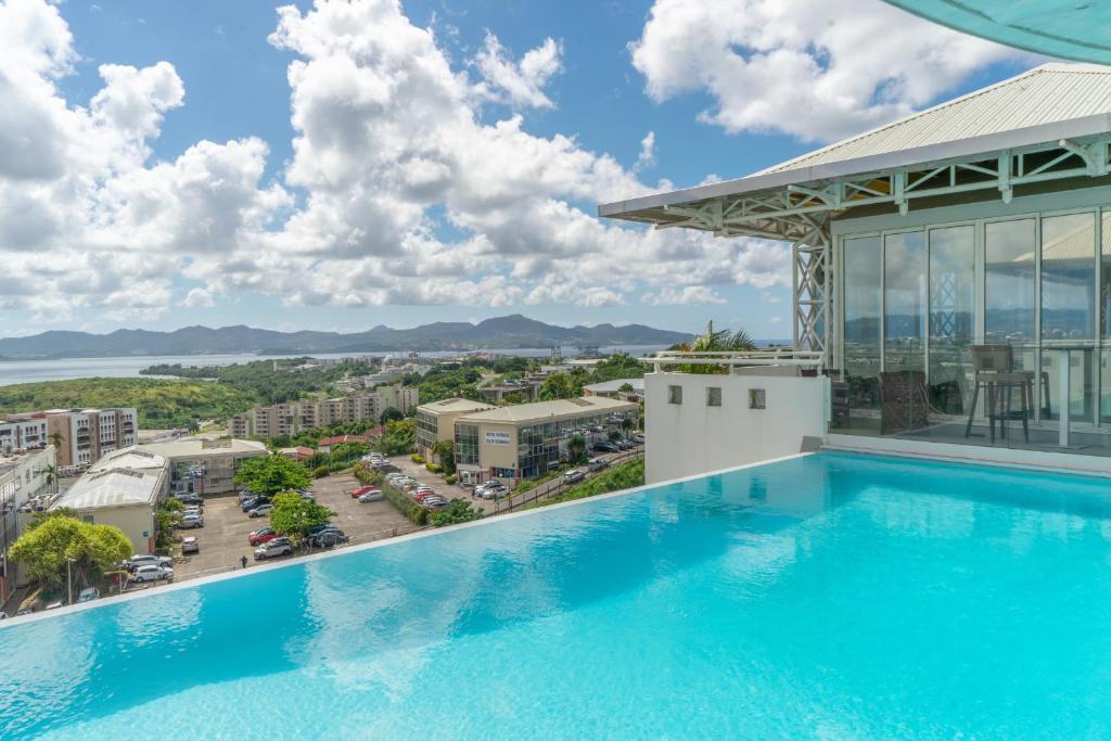 einen Pool auf dem Dach eines Gebäudes mit Aussicht in der Unterkunft Karibea La Valmenière Hôtel in Fort-de-France