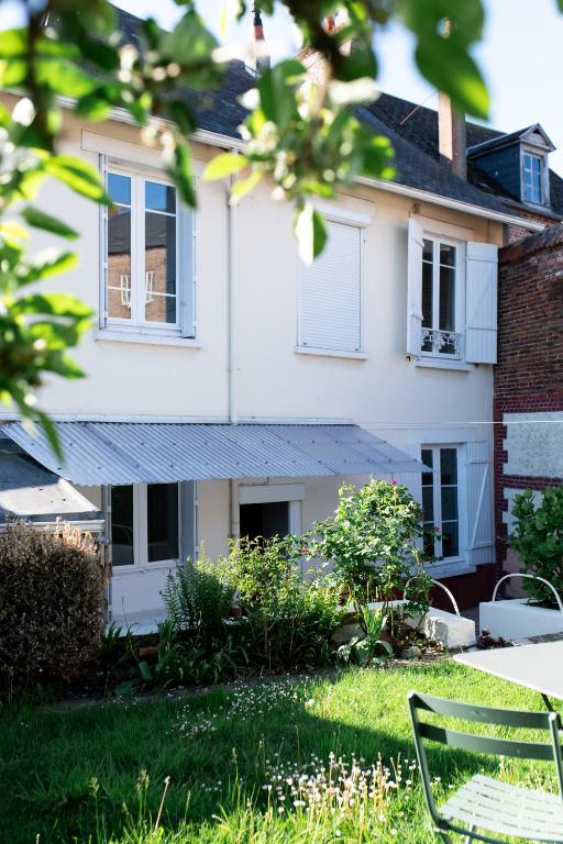 une maison blanche avec des fenêtres et une pelouse verte dans l'établissement La Montpensier - maison dans le centre ville d'Eu, à Eu