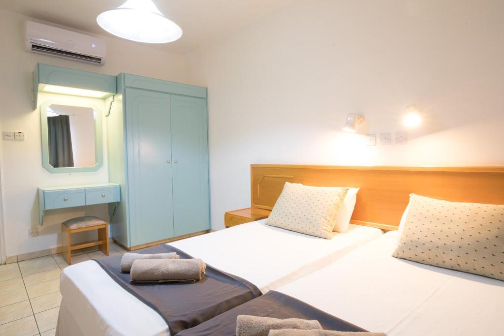 1 Schlafzimmer mit 2 Betten und einem Spiegel in der Unterkunft DebbieXenia Hotel Apartments in Protaras