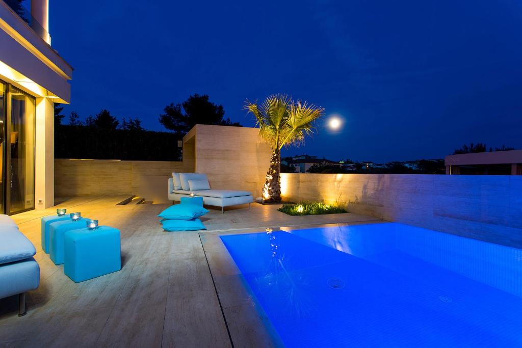un patio trasero con piscina por la noche en Boutique Hotel Valsabbion en Pula
