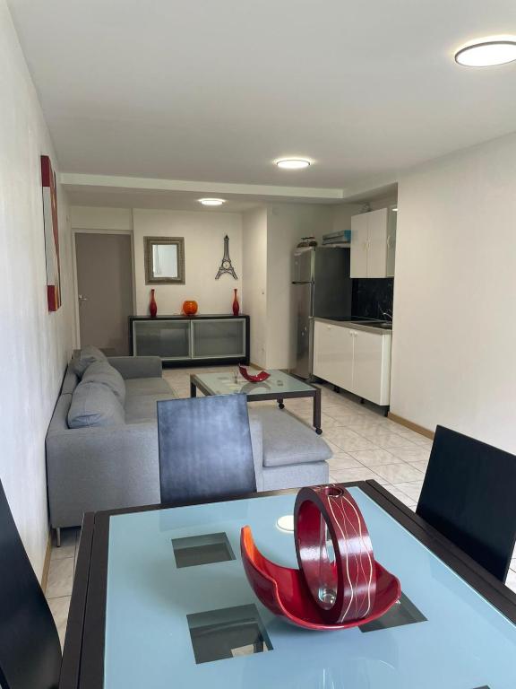 - un salon avec un canapé et une table avec une chaise rouge dans l'établissement Appartement idéalement situé, à Besançon