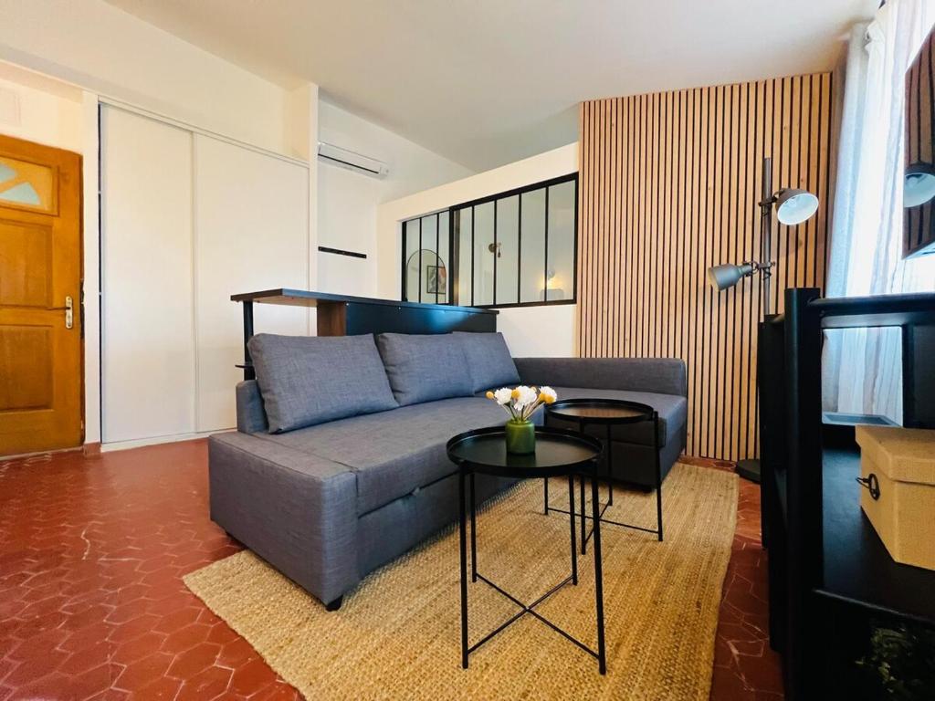 un salon avec un canapé bleu et une table dans l'établissement Grasse B - Two rooms 4 people Downtown - AIR-CONDITIONING, à Grasse