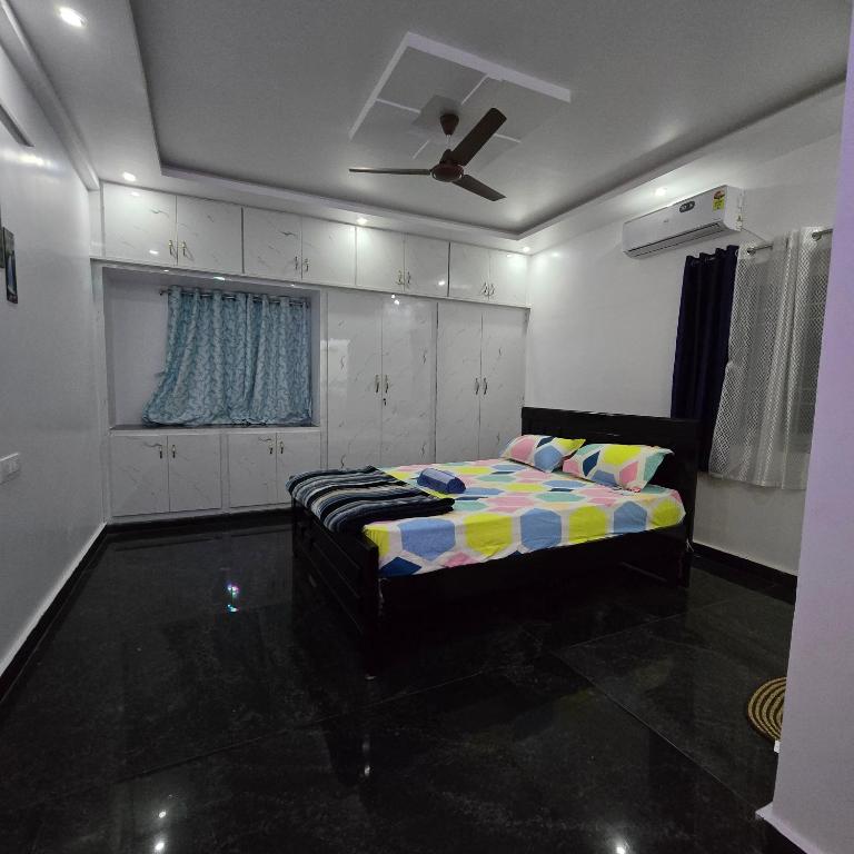 a bedroom with a bed and a ceiling fan at Padmini's home stay New apartment 2bhk in Tirupati