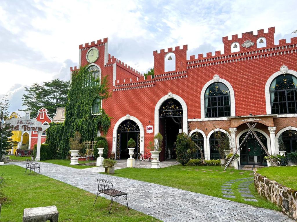 a large red brick building with a clock tower at Phuiyara Resort in Nakhon Nayok