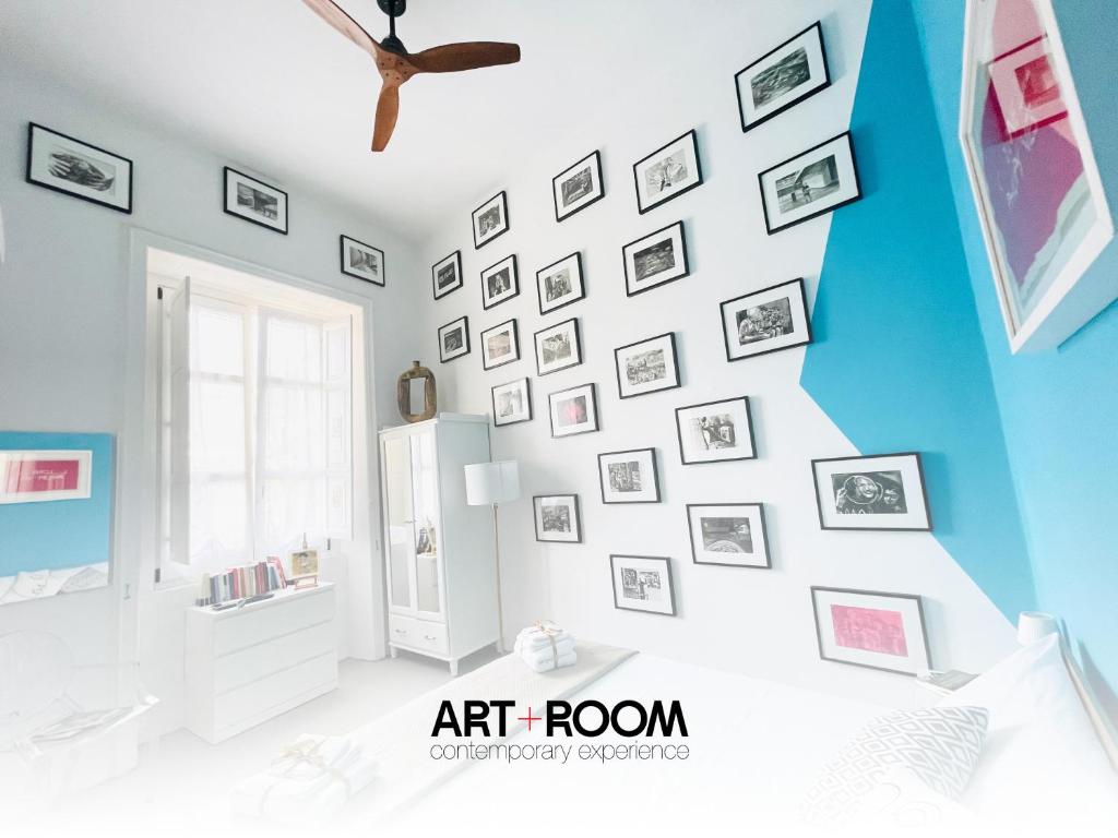 una habitación con una pared de cuadros en la pared en Hackert Art Room Apartment, en Caserta