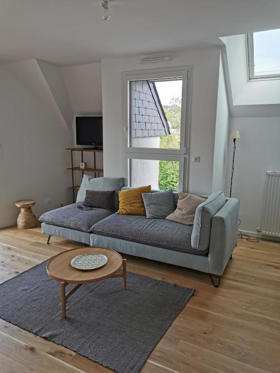 un salon avec un canapé bleu et une table dans l'établissement 2 room Apartment terrace near beach, à La Celle-sous-Gouzon