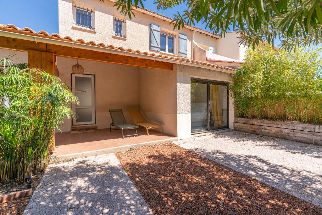 une maison avec une chaise assise sur une terrasse dans l'établissement La Brise douce YourHostHelper, à Sète