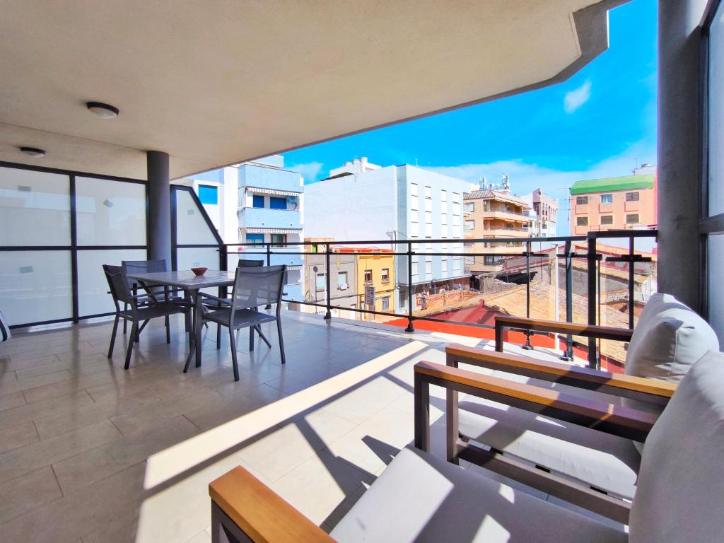 un balcone con tavolo e sedie su un edificio di Apartamento con Terraza junto al Mar en Moncofa a Moncófar