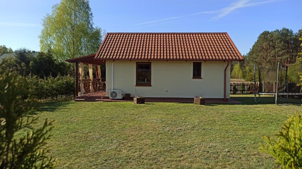 ein kleines weißes Haus mit einem roten Dach in der Unterkunft OcypLoveDomki, Ocypel - Bory Tucholskie, Balia in Ocypel