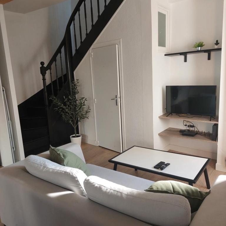 ein Wohnzimmer mit Sofa und Tisch in der Unterkunft Le refuge du lac in La Tessoualle