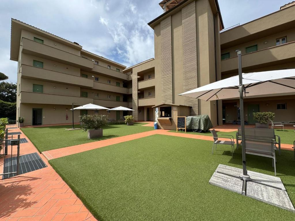 a courtyard of a building with a table and an umbrella at Residence San Francesco in Tirrenia