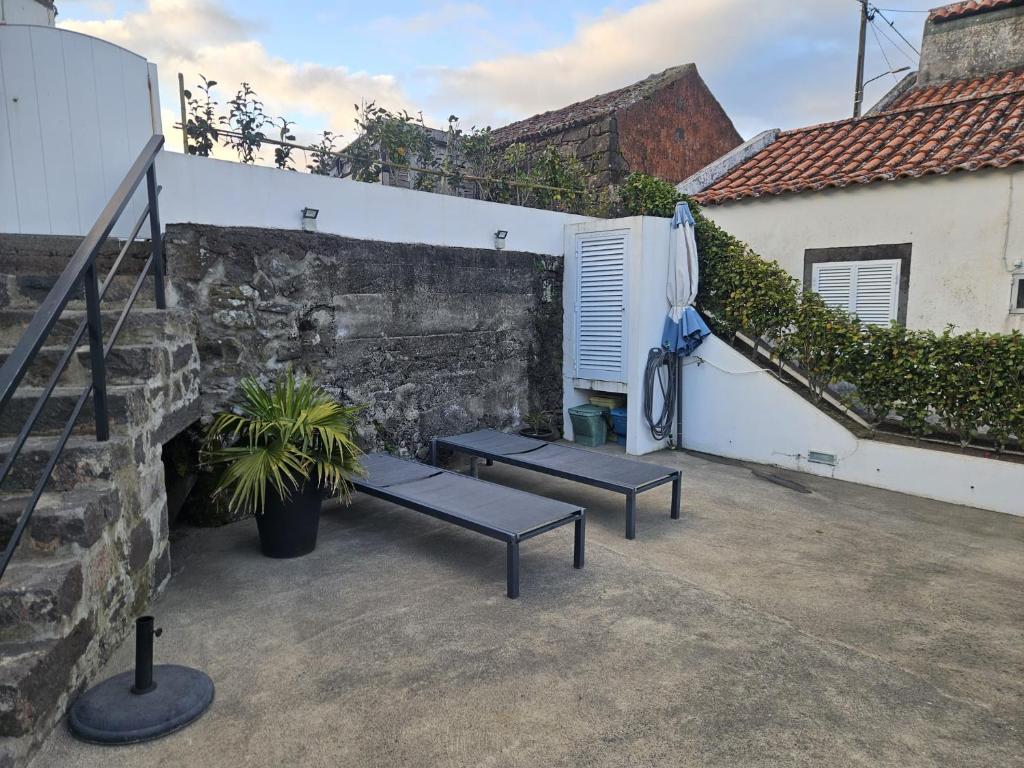 a patio with two benches next to a wall at Casa Vista da Marquesa in Nordeste