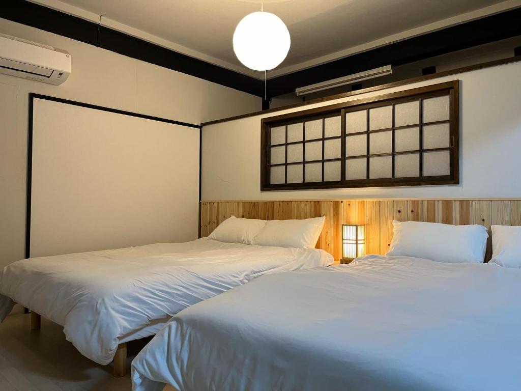 two beds sitting next to each other in a bedroom at 甘口派room in Obanazawa