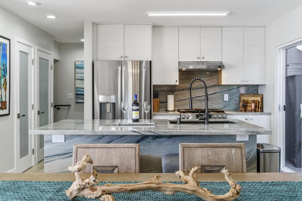 a kitchen with white cabinets and a island with a counter top at Tower 9 in Oceanside