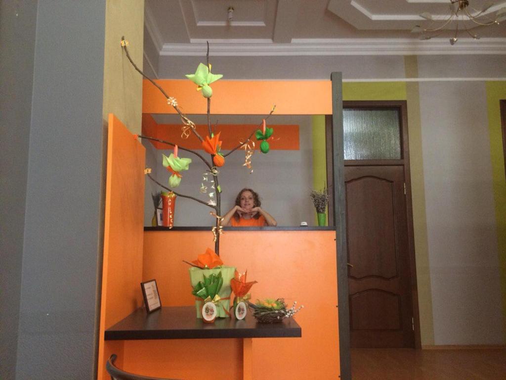 a woman in a mirror in an orange wall at Hostel Balkonsky in Rostov on Don