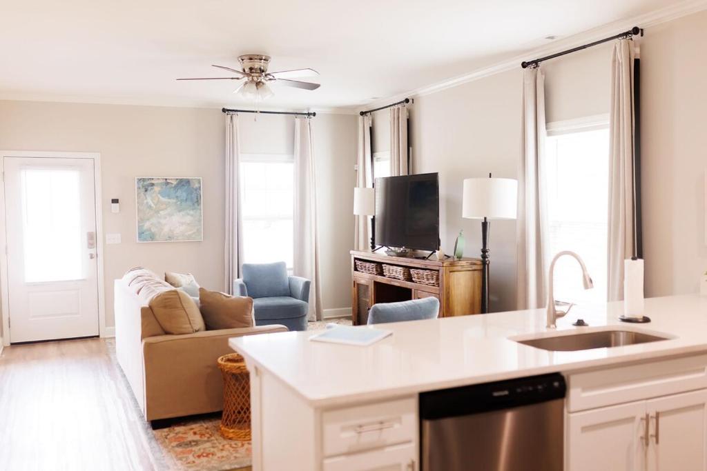 a kitchen and living room with a couch and a tv at The Cottages 2BR 2BA Dothan Pool Dog Park Pickle Ball Gym in Midland City