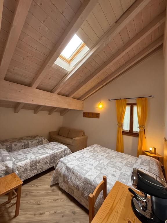 sypialnia z 2 łóżkami i świetlikiem w obiekcie Garnì Sella Cipriani w mieście Borgo