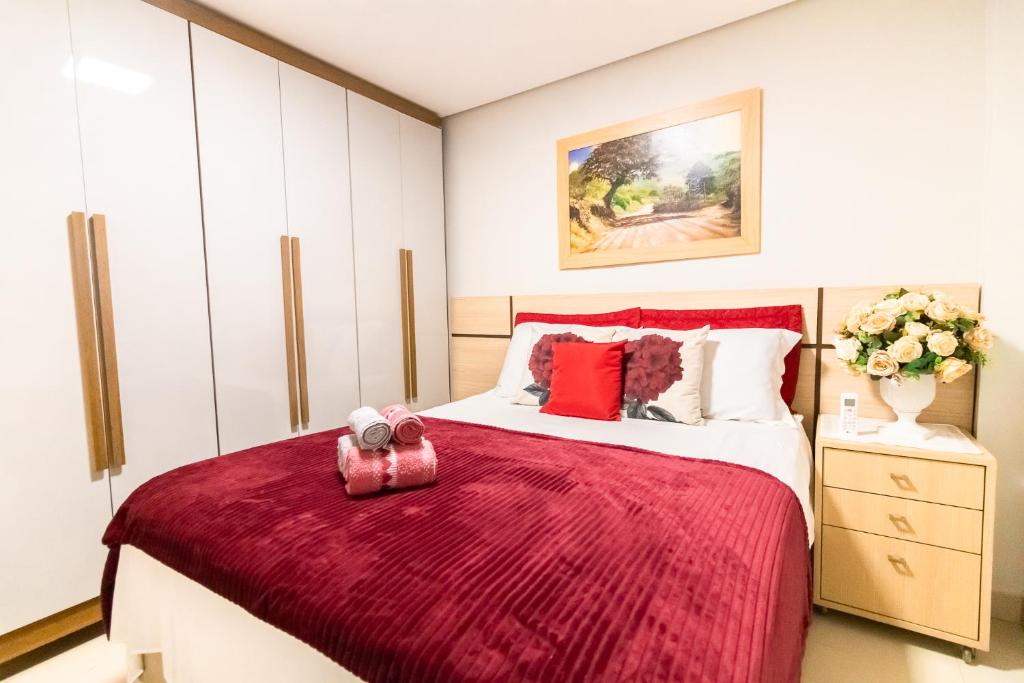 a bedroom with a large bed with a red blanket at OZPED Casas Particulares localização Cruzeiro in Brasilia