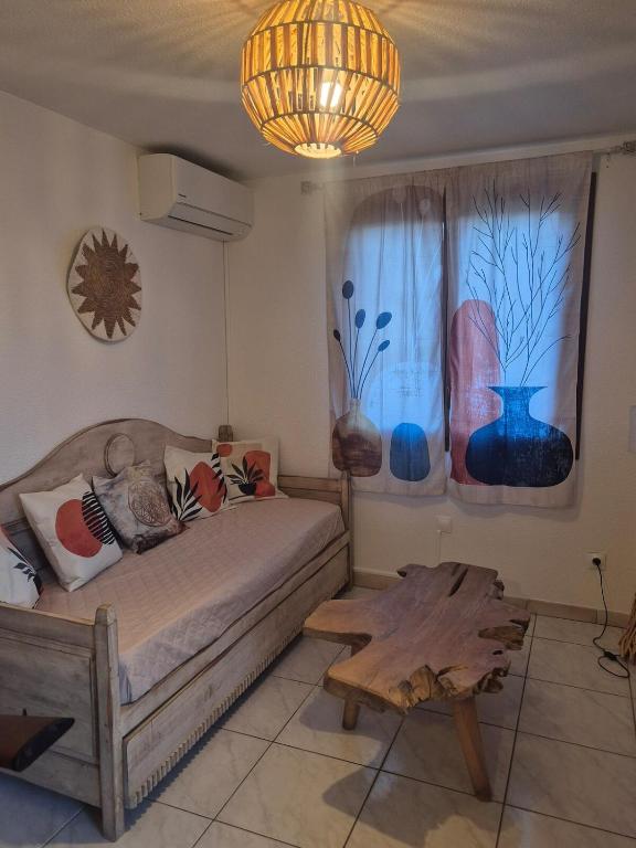 une chambre avec un lit, une table et une fenêtre dans l'établissement Havre de paix zen et cosy, à Saintes-Maries-de-la-Mer