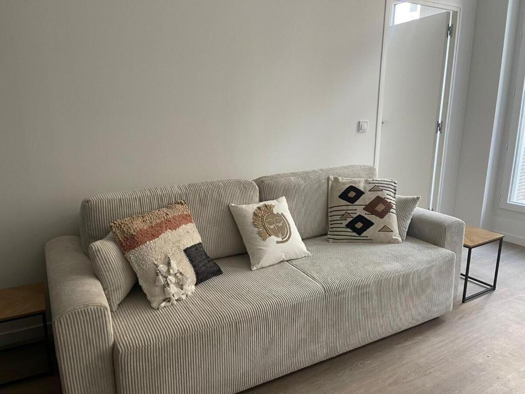 un canapé avec des coussins dessus dans un salon dans l'établissement Hyper center T2 Bohemian chic, à Marseille