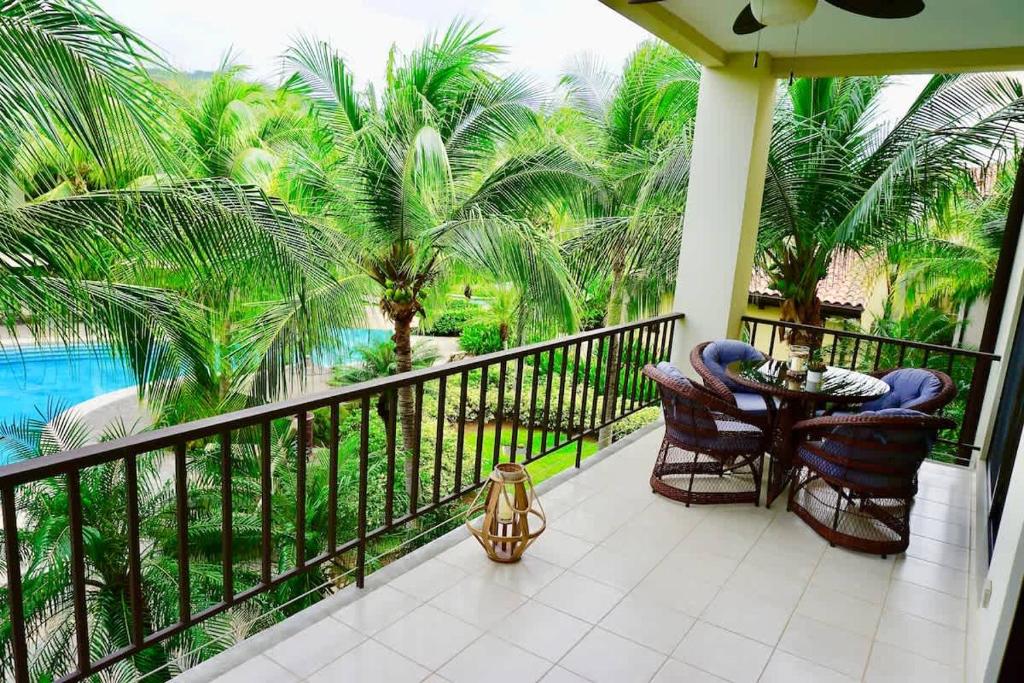 a balcony with a table and chairs and a pool at Luxurious Pacifico 2bed condo in Playa Coco in Coco