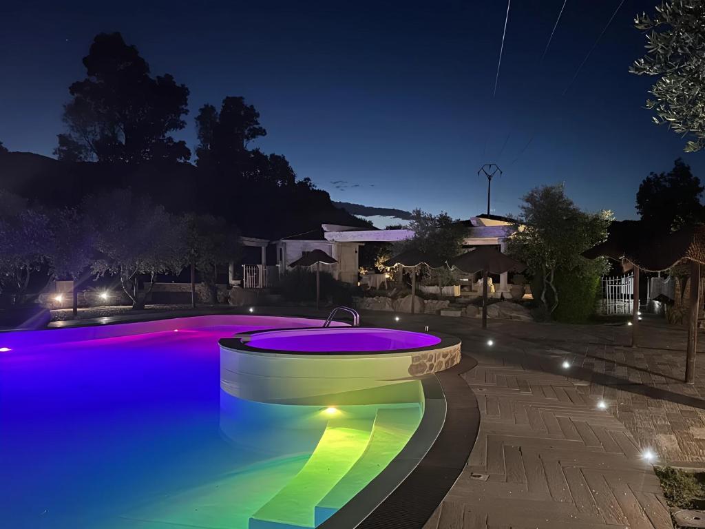 a swimming pool at night with lights in a yard at Appartamenti dolores castle in Marina di Campo Airport