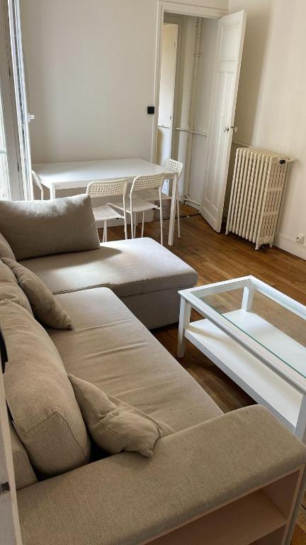 un salon avec deux canapés et une table dans l'établissement Appartement proche Roland Garros, à Boulogne-Billancourt