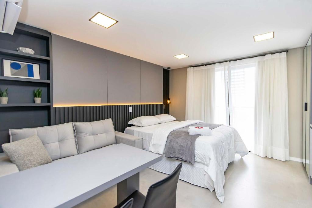 een woonkamer met twee bedden en een bank bij Studio Completo e Refinado no All Batel - BAT1516 in Curitiba