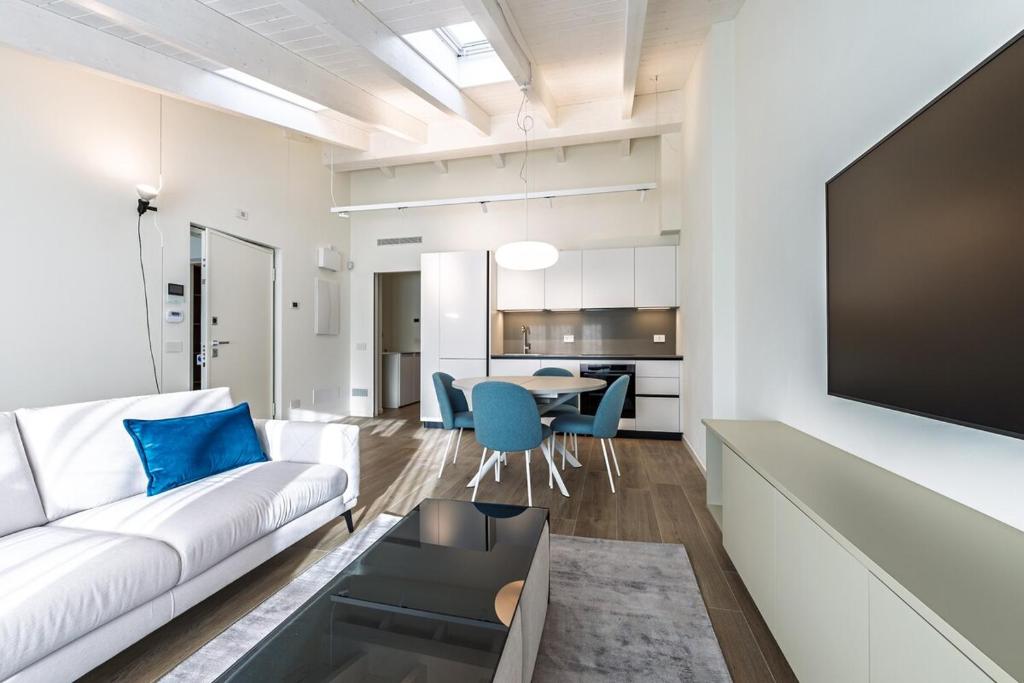 a living room with a white couch and a table at Bilocale Vitruviano Treviglio Milano Upper Stay in Treviglio