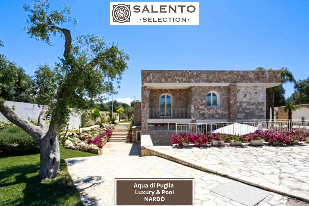 a stone house with a tree in front of it at Aqua di Puglia Luxury & Pool - Salento Selection in Nardò