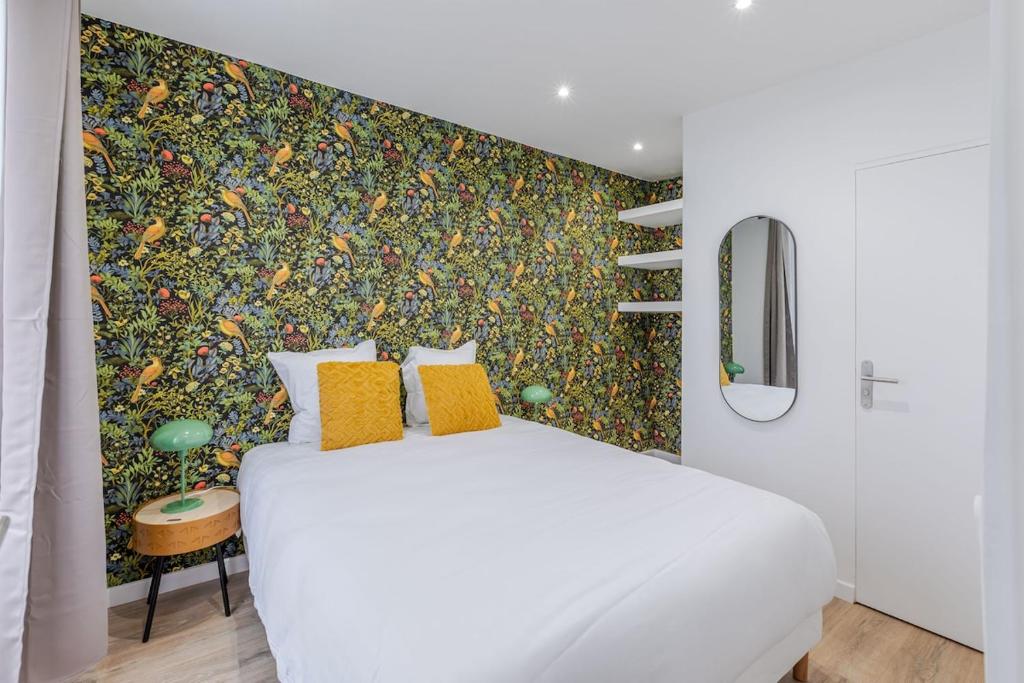 - une chambre avec un lit blanc et un mur coloré dans l'établissement Nid douillet pour deux cœur du 19e arrondissement, à Paris