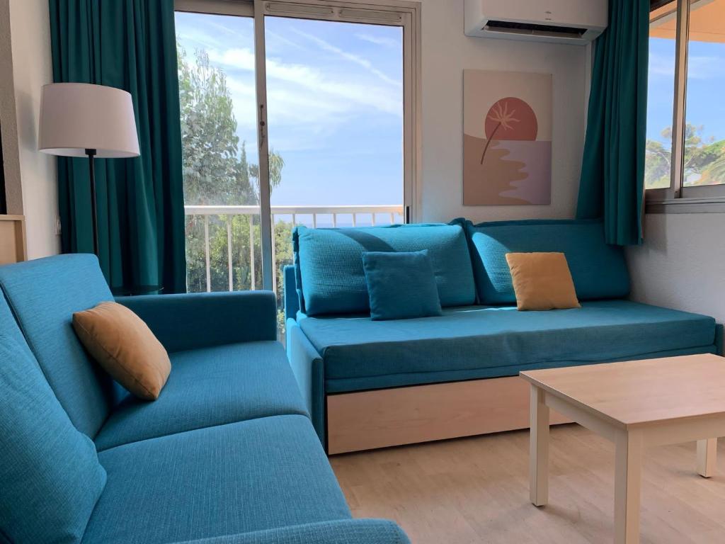 un salon avec un canapé bleu et une table dans l'établissement Villa Livia, à La Celle-sous-Gouzon