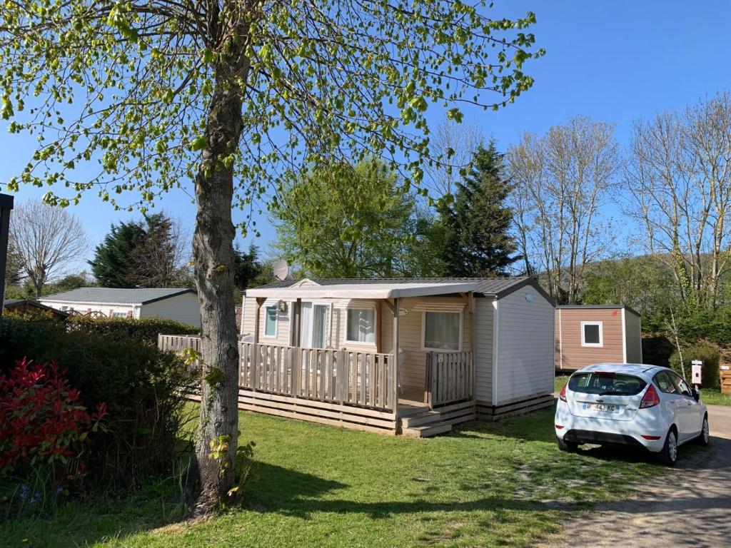 Une petite maison avec une voiture garée devant elle dans l'établissement hébergement sur camping 5 étoiles proche mer proche centre Houlgate, à Houlgate