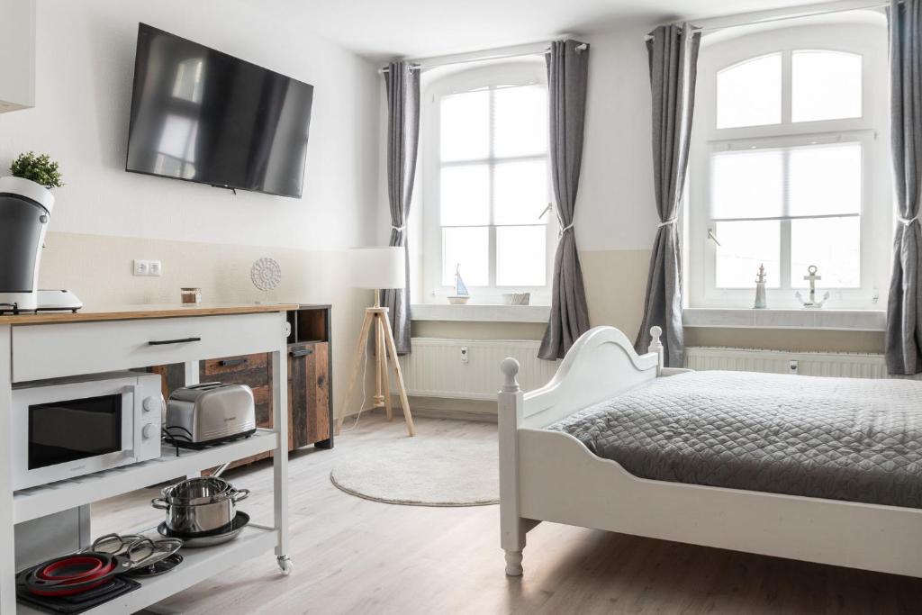 a bedroom with a bed and a tv on the wall at SchaeBu! 1 Apartment Die Ostsee am Altmarkt in Cottbus