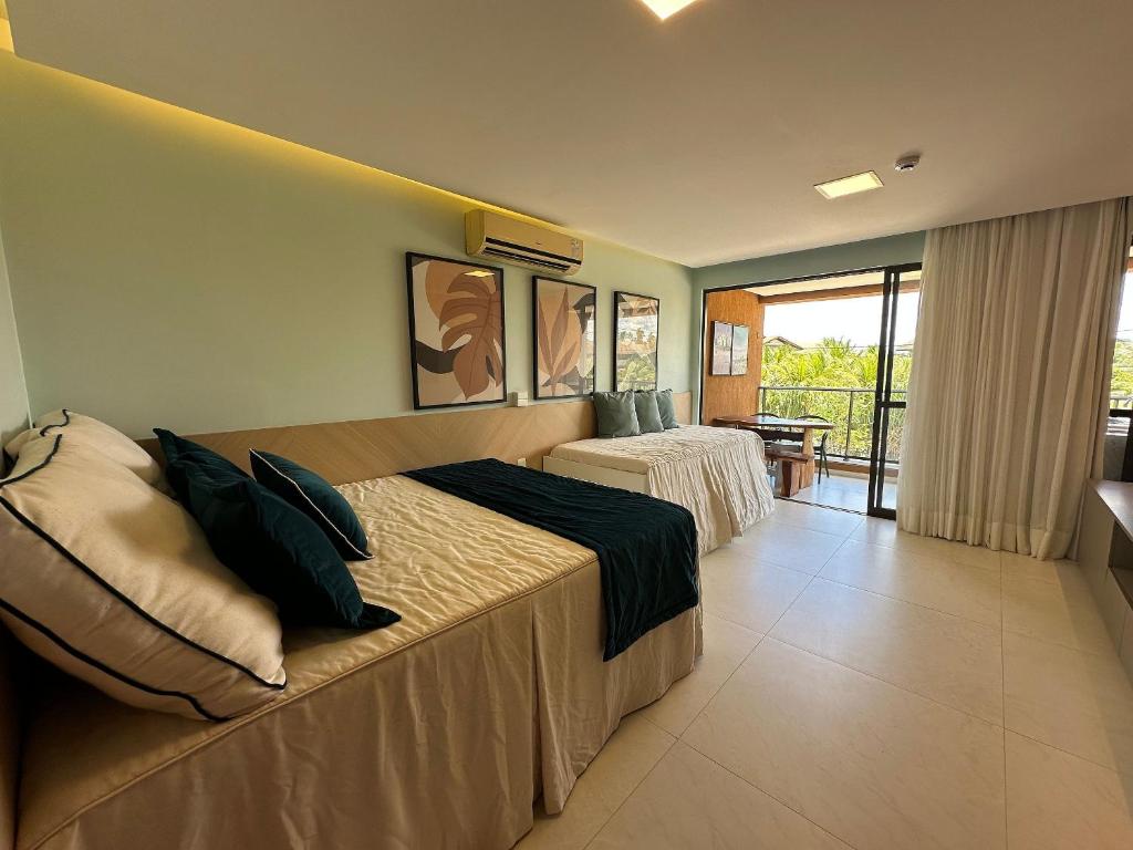 a hotel room with a bed and a balcony at Flats, Apartamentos e Bangalôs na Praia dos Carneiros, ao lado da Igrejinha de São Benedito in Praia dos Carneiros